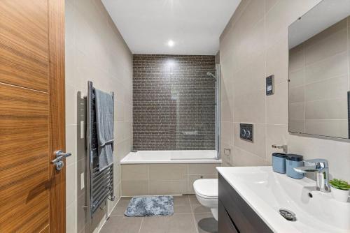 a bathroom with a sink and a toilet and a tub at Modern Luxe Living in Lincoln - Flat 3 in Lincolnshire