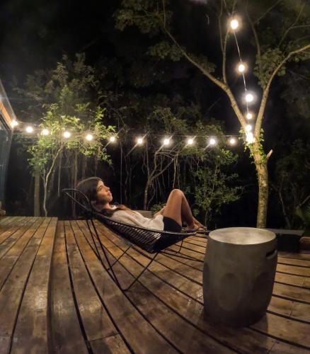 a woman laying in a hammock on a deck at night at Tiny House with Views and Jacuzzi in Anton Valley in Las Colinas