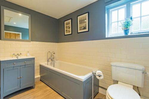 łazienka z wanną, toaletą i umywalką w obiekcie Hearts Delight Cottage by Bloom Stays w mieście Bridge