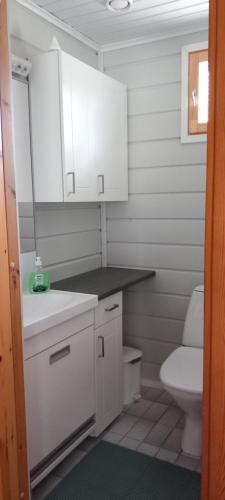 ein kleines Bad mit weißen Schränken und einem WC in der Unterkunft Tassutupa in Hulmi