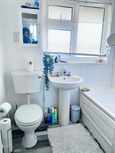 a bathroom with a toilet and a sink and a tub at Room in apartment home-Stretford in Manchester