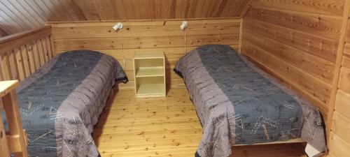 Habitación con 2 camas en una cabaña de madera en Tassutupa, en Hulmi