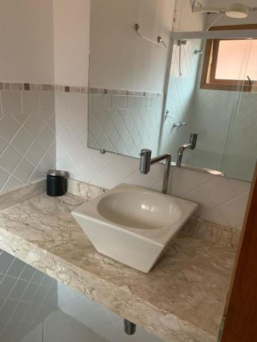 a white sink in a bathroom with a mirror at excelente casa em Juquehy in São Sebastião