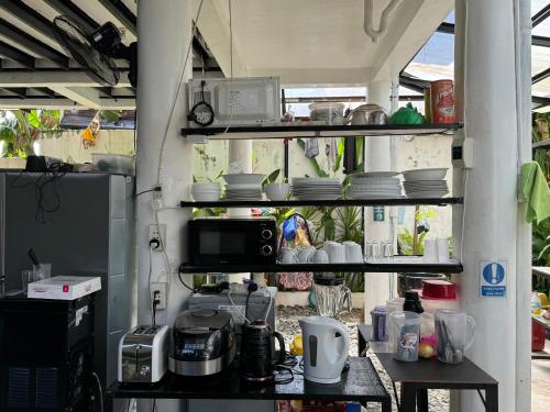 a kitchen with a counter with dishes on shelves at Mahajab Homestay SIARGAO in General Luna