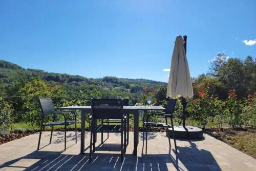 a table and chairs and an umbrella on a patio at C'est Chouette les Vosges aux portes de l'Alsace et à proximité de Saint Dié des Vosges in Senones