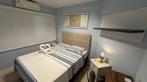 a small bedroom with a bed with a bow on it at Moderno e lindo apt no centro de Foz e perto do PY in Foz do Iguaçu