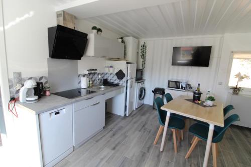 a kitchen with a table and a kitchen with white appliances at C'est Chouette les Vosges aux portes de l'Alsace et à proximité de Saint Dié des Vosges in Senones