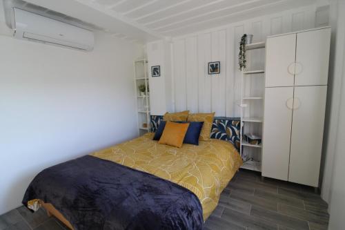 a bedroom with a bed with blue and orange pillows at C'est Chouette les Vosges aux portes de l'Alsace et à proximité de Saint Dié des Vosges in Senones