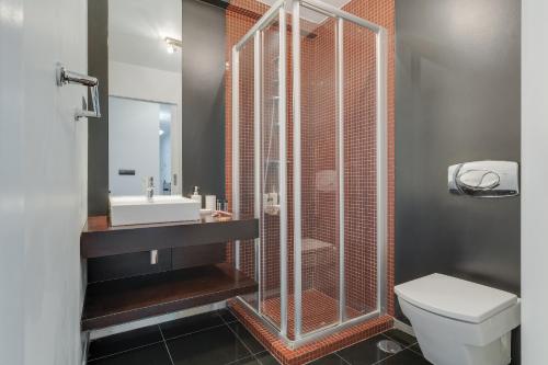 een badkamer met een douche, een toilet en een wastafel bij Ramos Apartment by HRM in Funchal