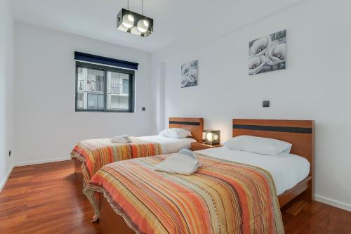 een slaapkamer met 2 bedden en een raam bij Ramos Apartment by HRM in Funchal