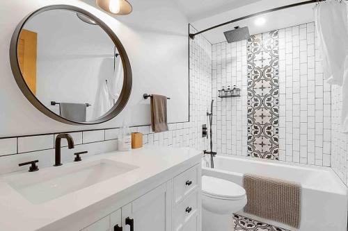 une salle de bain blanche avec un lavabo et un miroir dans l'établissement 2 bedroom Getaway on the River/close to marina, à Belle River