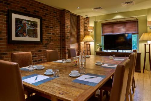 a dining room with a large wooden table and chairs at Hotel du Vin Cheltenham in Cheltenham