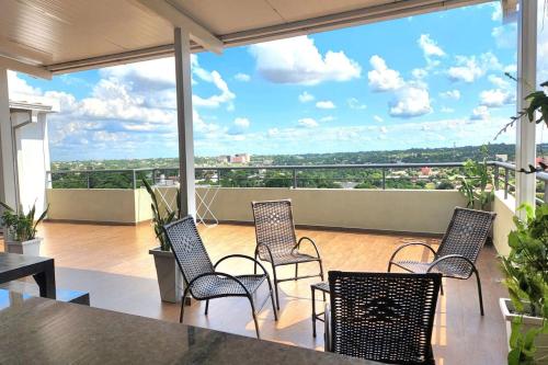 a group of chairs sitting on a balcony with a view at Apartamento confortable in Ciudad del Este