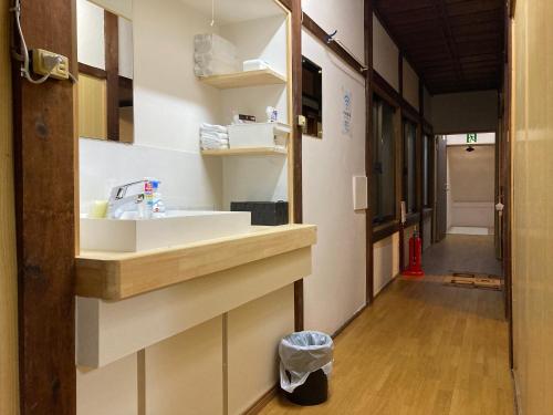 a kitchen with a sink and a hallway at わがらん家 -えんつなぎ- in Kumano