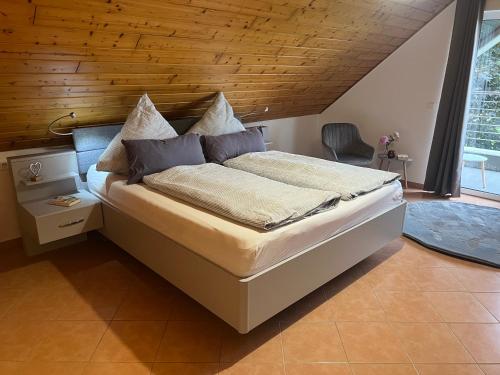 リューディングハウゼンにあるHof Dalhausの木製の天井のベッドルーム1室(大型ベッド1台付)