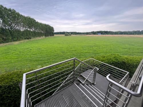 a metal bench with a large field in the background at Hof Dalhaus in Lüdinghausen