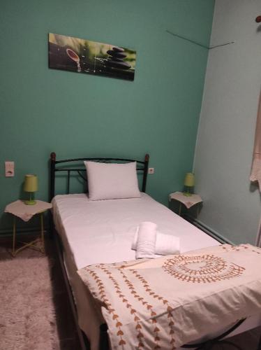 a bedroom with a bed and two side tables at NASOS APARTMENT METEORA in Kalabaka