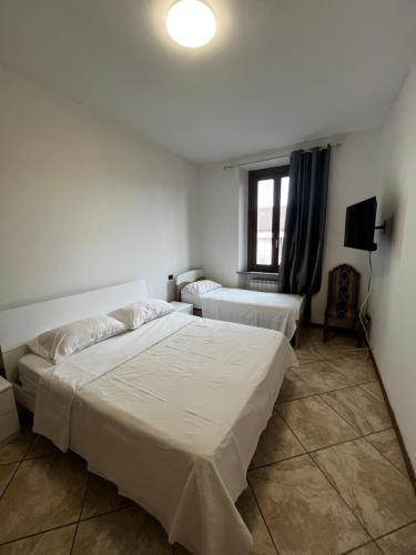 1 dormitorio con 2 camas y TV. en Appartamento Mira, en Cislago