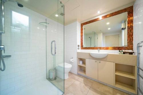 a bathroom with a toilet and a sink and a shower at Absolute Lakeside in Queenstown