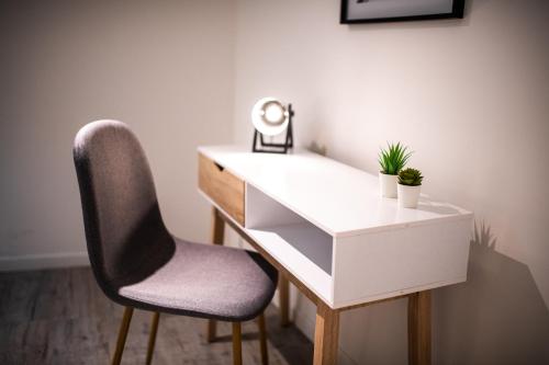 - un bureau avec une chaise et un bureau blanc avec un miroir dans l'établissement KASA LORETTE - WIFI - TV - 2 chambres, à Lorette