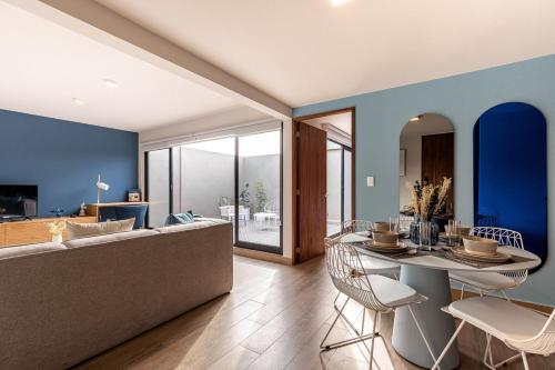 a living room with a couch and a table and chairs at Roma Norte Trendy Apartments by VIATO in Mexico City