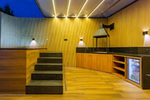 a staircase in a kitchen with wooden walls and a counter at Drops Motel Brasília in Brasilia