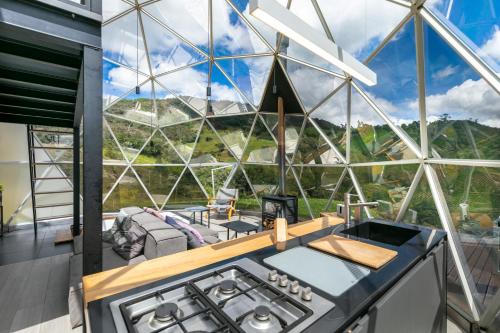 a kitchen with a stove and a large window at Mirror Glamping in Sesquilé