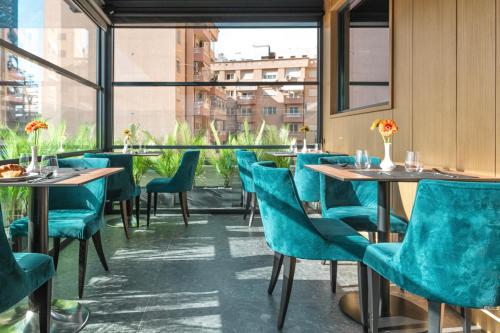 a restaurant with blue chairs and tables and a window at Central Inn Hotel in Tirana