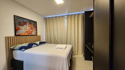 een kleine slaapkamer met een bed en een raam bij Barra Stella do Mar Studio in Salvador