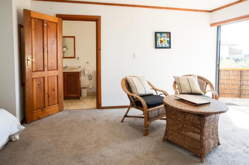 um quarto com uma cama, uma mesa e cadeiras em African Perfection 1 em Jeffreys Bay