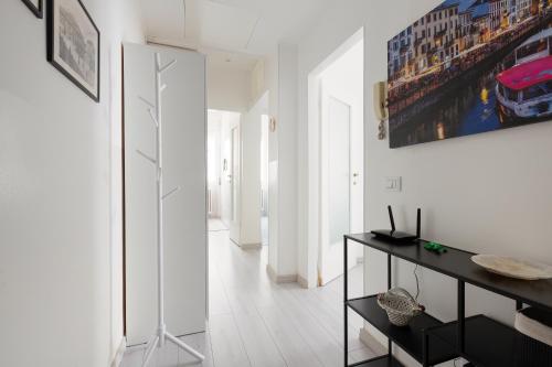 Habitación blanca con escritorio y una pintura en la pared. en Apartment with Balcony -Bisceglie Red Line Subway en Milán