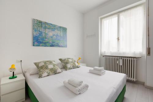 Un dormitorio blanco con una cama con toallas. en Apartment with Balcony -Bisceglie Red Line Subway en Milán