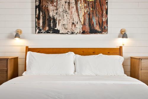 a bed with white pillows and a painting above it at Boutique Room steps from Downtown Mall Rose Jean - Room 4 in Charlottesville