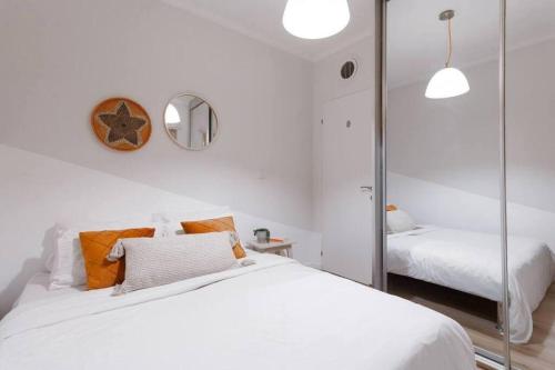 ein weißes Schlafzimmer mit einem Bett und einem Spiegel in der Unterkunft 1 Bedroom Suite Yona Hotel in Tel Aviv