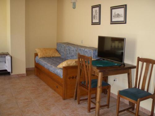 a living room with a couch and a desk with a laptop at Hostal Pineda in Cervera de Pisuerga
