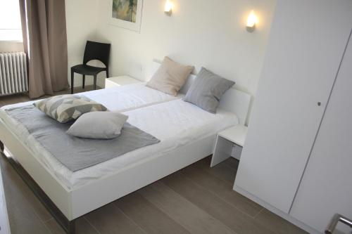 a white bed with pillows on it in a room at Prince's165 in Knokke-Heist