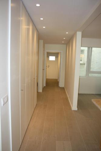 a hallway with white walls and a tile floor at Prince's165 in Knokke-Heist