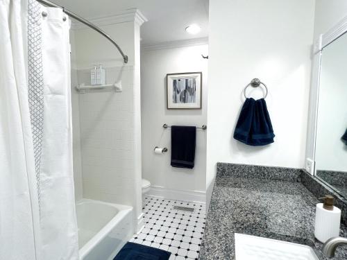 Baño blanco con bañera y lavamanos en Modern 1BR apt in the heart of downtown Wilmington en Wilmington