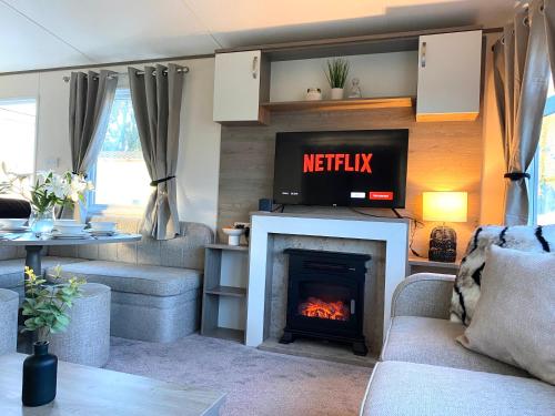 a living room with a fireplace and a tv at Short escape within Billing Aquadrome in Northampton