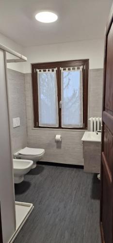 La salle de bains est pourvue de 2 toilettes, de 2 lavabos et d'une fenêtre. dans l'établissement Villa Terzaghi, à Gorla Minore