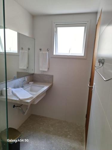 a bathroom with a sink and a window at Apartamento Morro do Careca in Natal