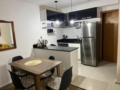 uma cozinha com uma mesa e um frigorífico de aço inoxidável em Edificio DaLuis em Punta del Este