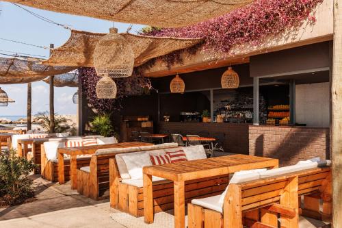a restaurant with wooden tables and chairs on a patio at Saccharum - Resort and Spa - Savoy Signature in Calheta