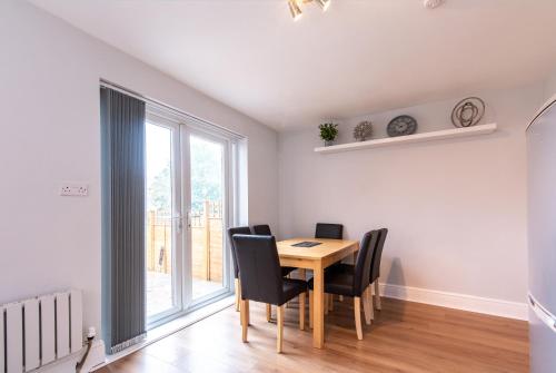 comedor con mesa, sillas y ventana en 2 Bedroom House in Chilwell - Perfect for Families and Business, en Beeston