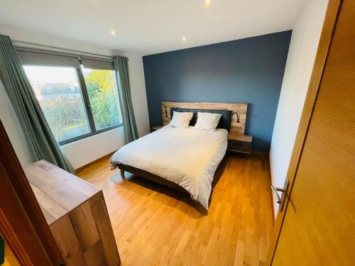 um quarto com uma cama e uma grande janela em Villa d’architecte avec piscine chauffée em Ligny-en-Cambrésis
