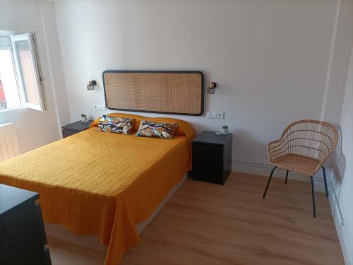 a bedroom with a bed and a chair and a window at Precioso Apartamento Nuevo Céntrico en Santander in Santander
