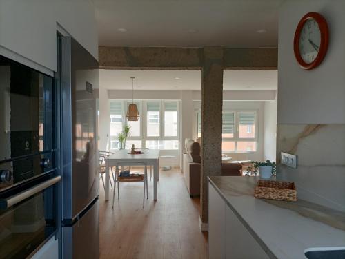 サンタンデールにあるPrecioso Apartamento Nuevo Céntrico en Santanderのキッチン、リビングルーム(テーブル、時計付)
