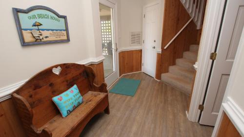 a hallway with a wooden bench with a pillow on it at Oceanside, Private Pool, Hot Tub, Community Pool, CD7, Sandfiddler Lodge in Duck