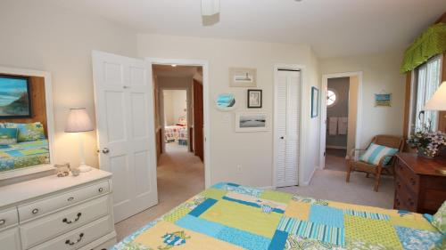 a bedroom with a bed and a dresser and a room at Oceanside, Private Pool, Hot Tub, Community Pool, CD7, Sandfiddler Lodge in Duck