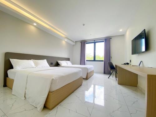 Pokój hotelowy z 2 łóżkami i biurkiem w obiekcie The Luxe Hotel Châu Đốc w mieście Châu Đốc